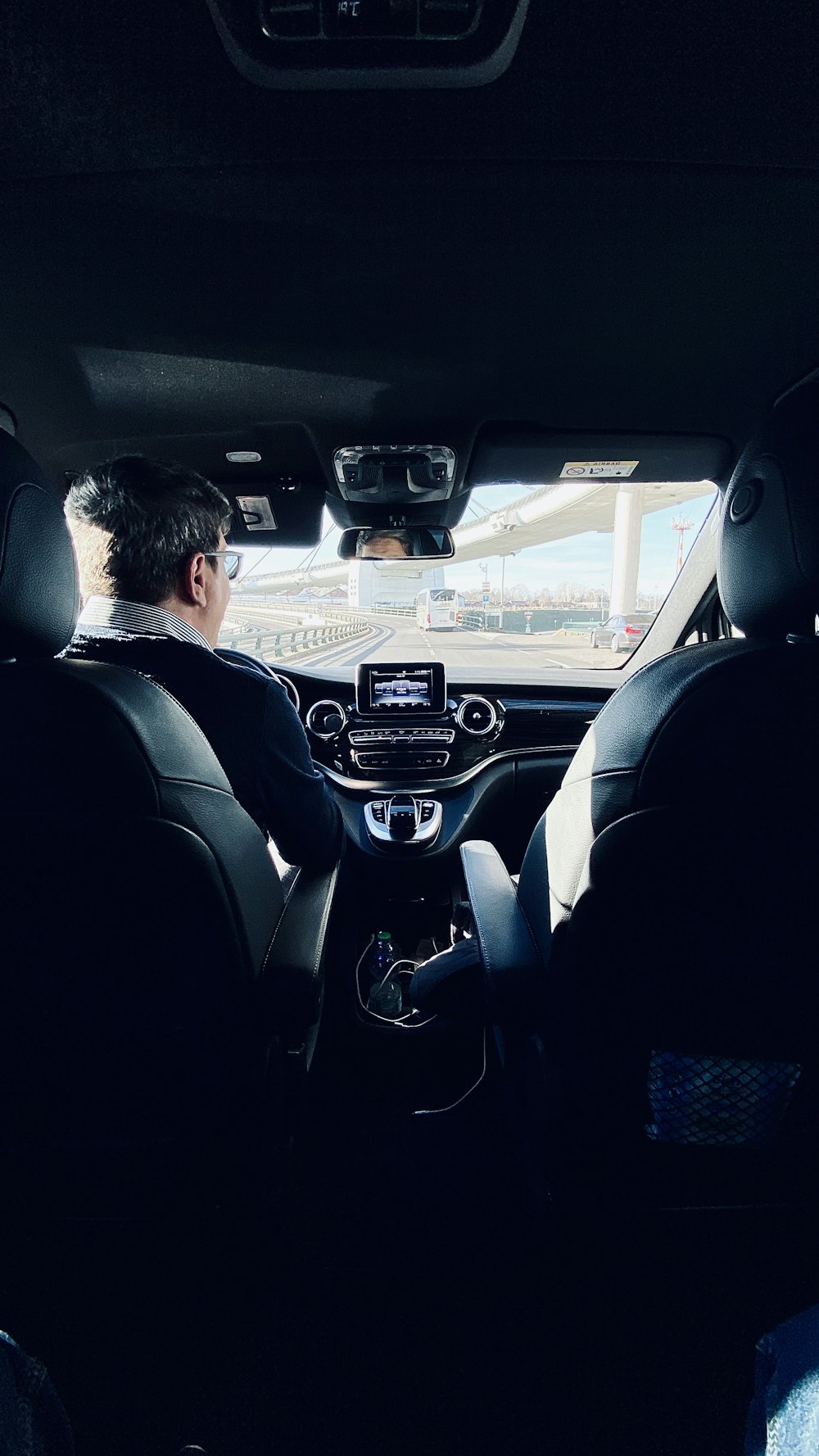 Chauffeur in a suit driving an executive car